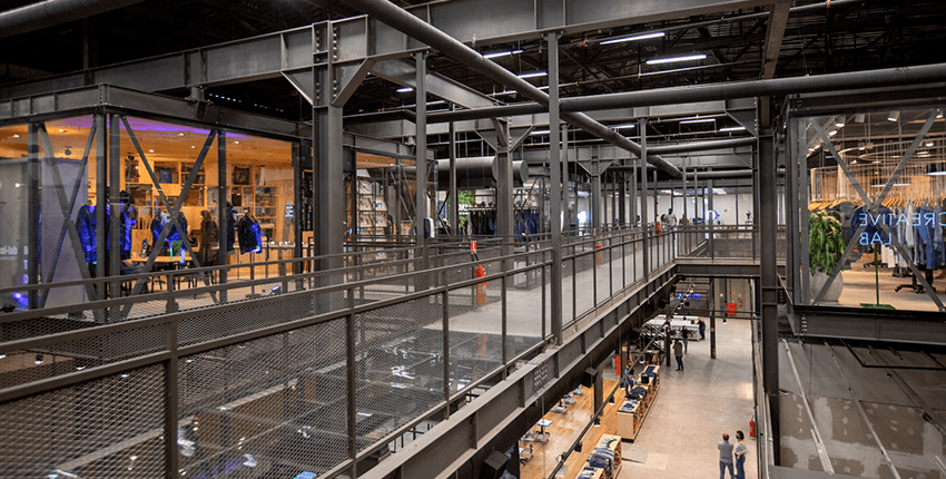 Visão da parte interna da denim city sp mostrando sua estrutura. Algumas lojas também aparecem na imagem.